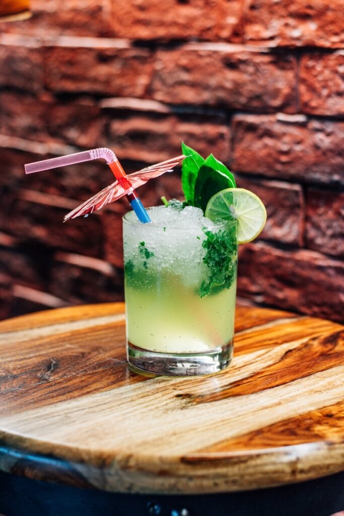 a glass with a green drink and two straws