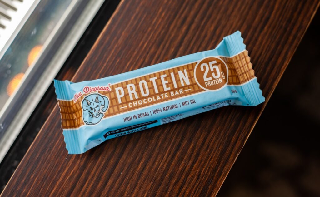 A protein bar rests on a wooden surface.