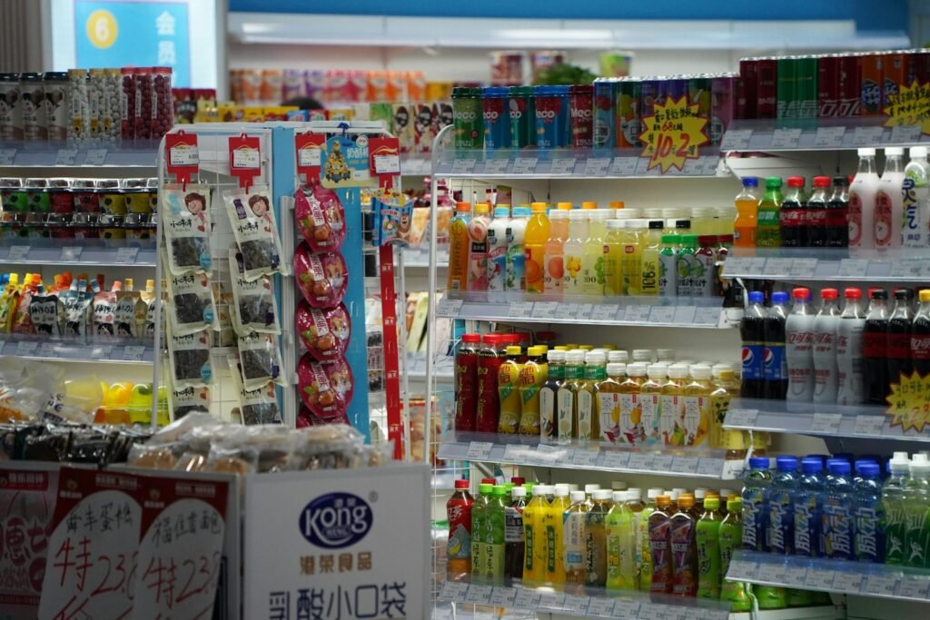 Shelves stocked with drinks and snacks in a store.