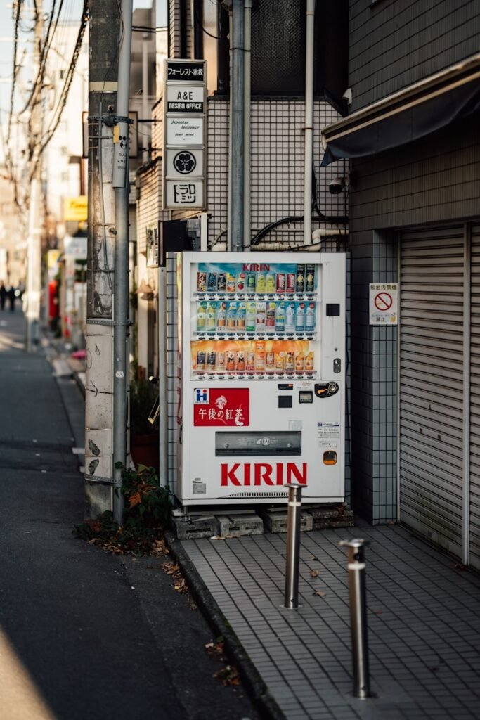 A white kirin vending machine on a city sidewalk.